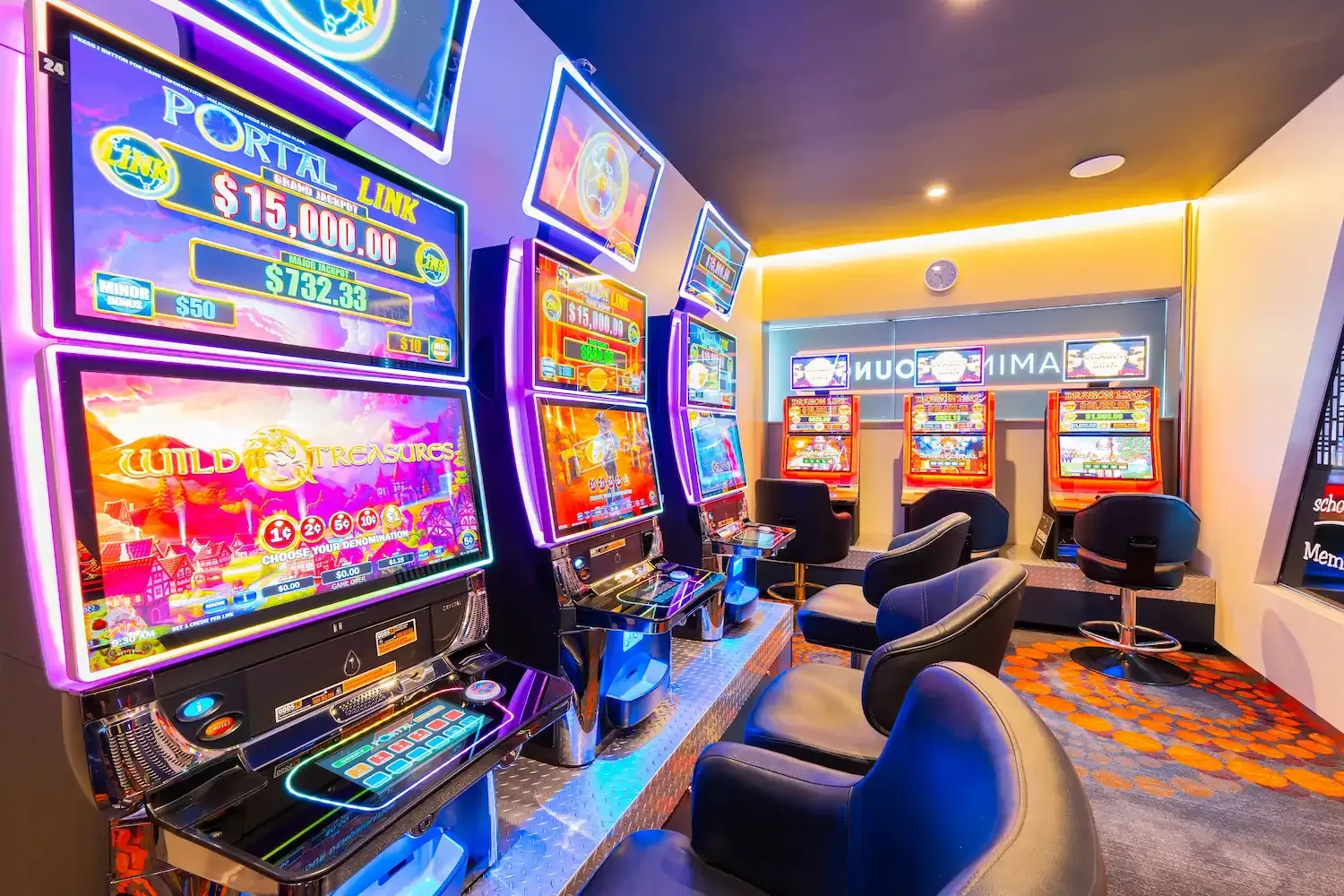 Espacio representativo del hotel: Una zona de juegos iluminada con máquinas electrónicas y asientos.