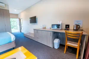 Espacio representativo del hotel: Habitación de hotel con cama, escritorio y televisor.