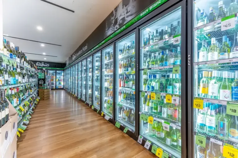Espacio representativo del hotel: Un pasillo de bebidas con refrigeradores surtidos y estantes.
