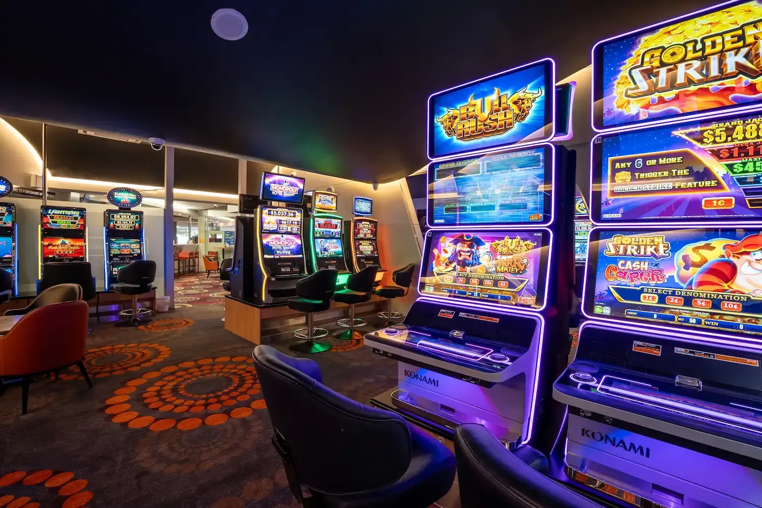 Espacio representativo del hotel: Una sala de videojuegos muy iluminada con filas de máquinas coloridas.