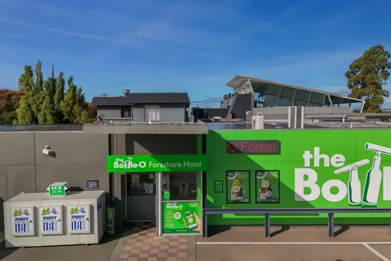 Espacio representativo del hotel: La fachada verde de un hotel destaca bajo un cielo azul despejado.