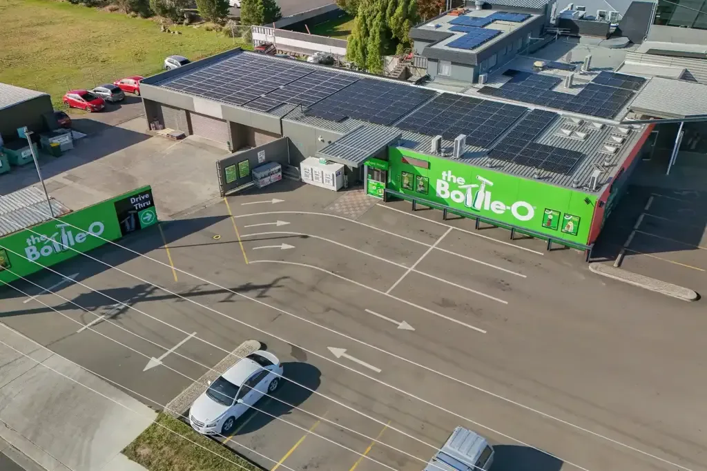 Espacio representativo del hotel: Vista aérea de un edificio comercial con estacionamiento señalizado y autos.