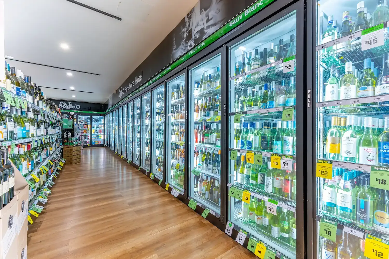 Espacio representativo del hotel: Un pasillo de tienda con estantes y refrigeradores de bebidas con puertas de vidrio.