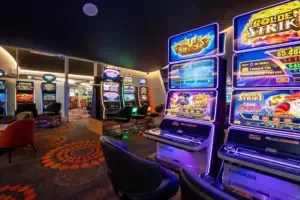 Espacio representativo del hotel: Un salón recreativo iluminado con máquinas de videojuegos coloridas y asientos.