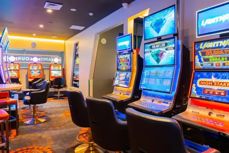 Espacio representativo del hotel: Una sala de juegos iluminada con máquinas electrónicas y asientos.