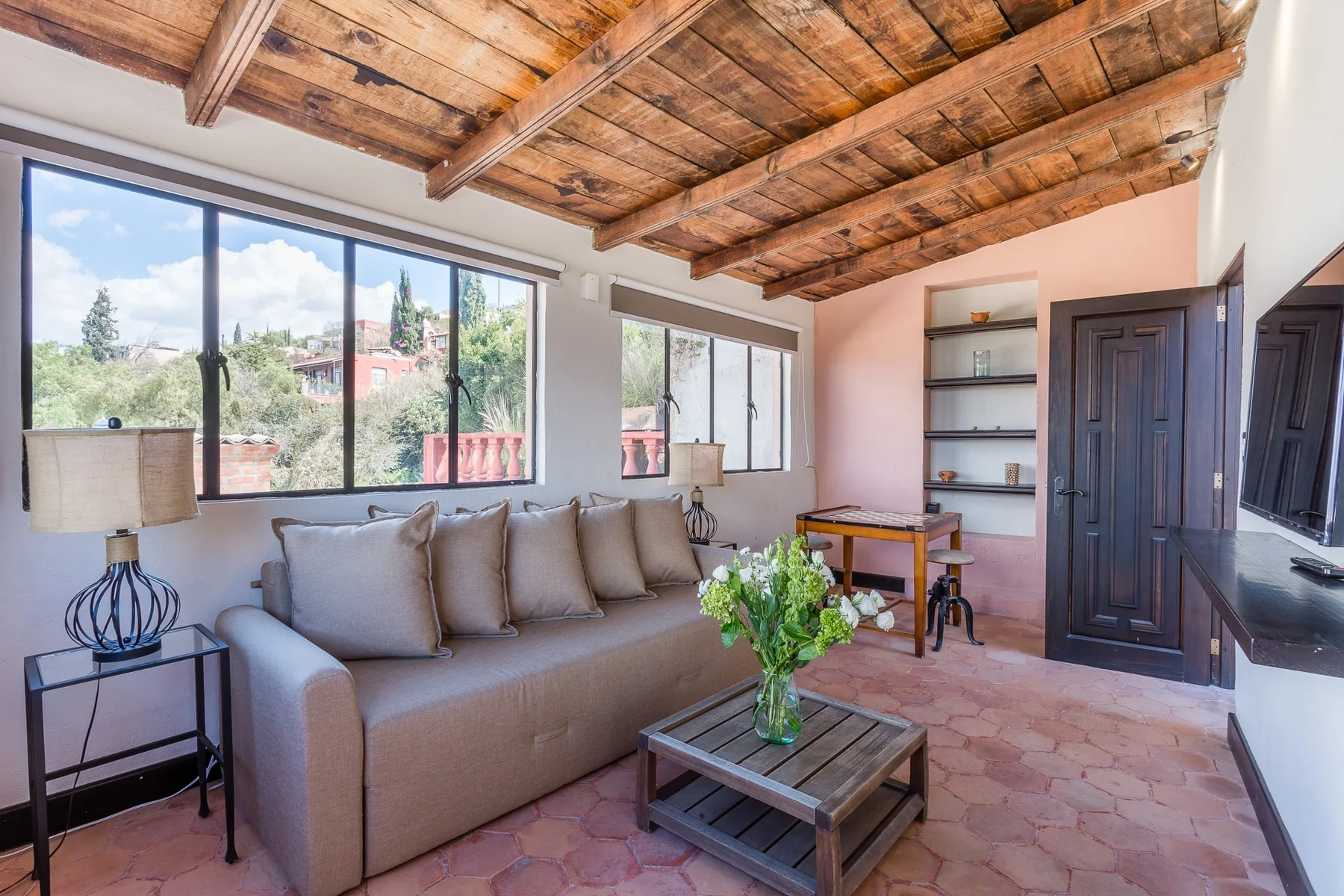 A living room with seating, a coffee table, and large windows.