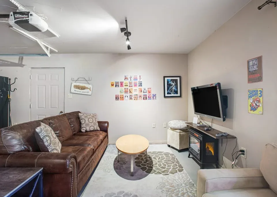 A living room with leather seating, a television, and a round coffee table.