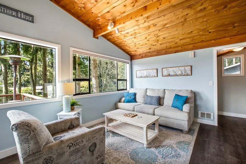 A bright living room with a sectional seating area and large windows.