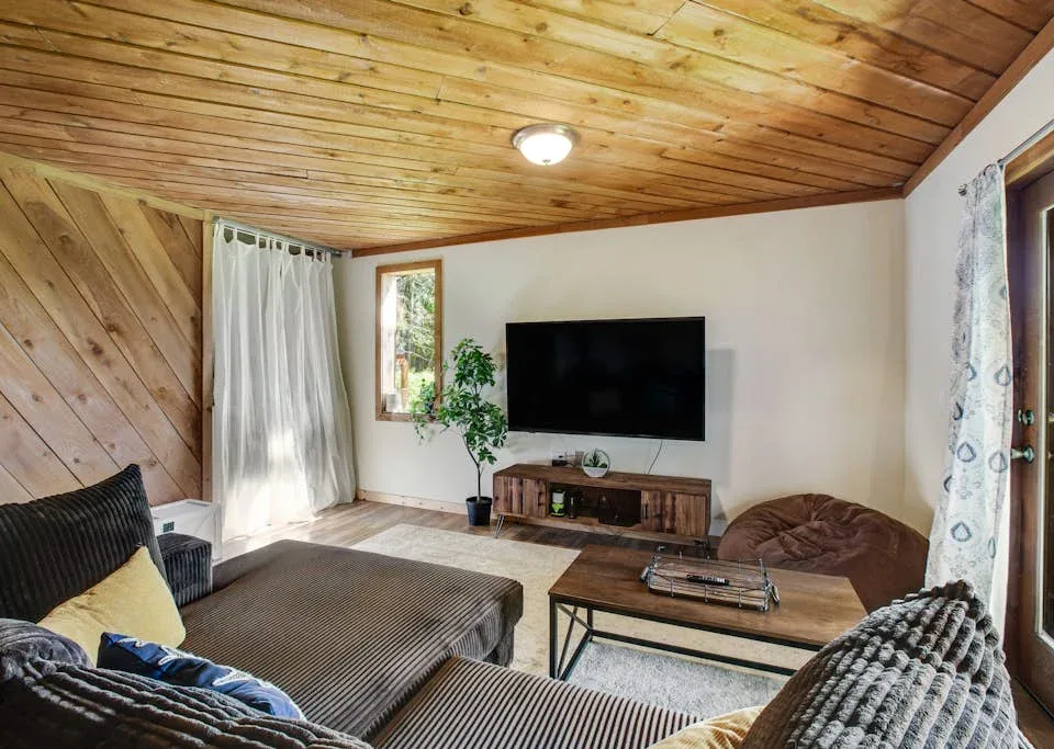 A living room with a television, seating, and a wooden coffee table.