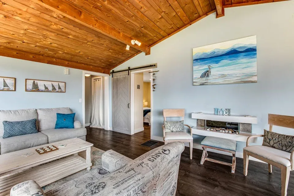 A living room with seating, a coffee table, and a wooden ceiling.