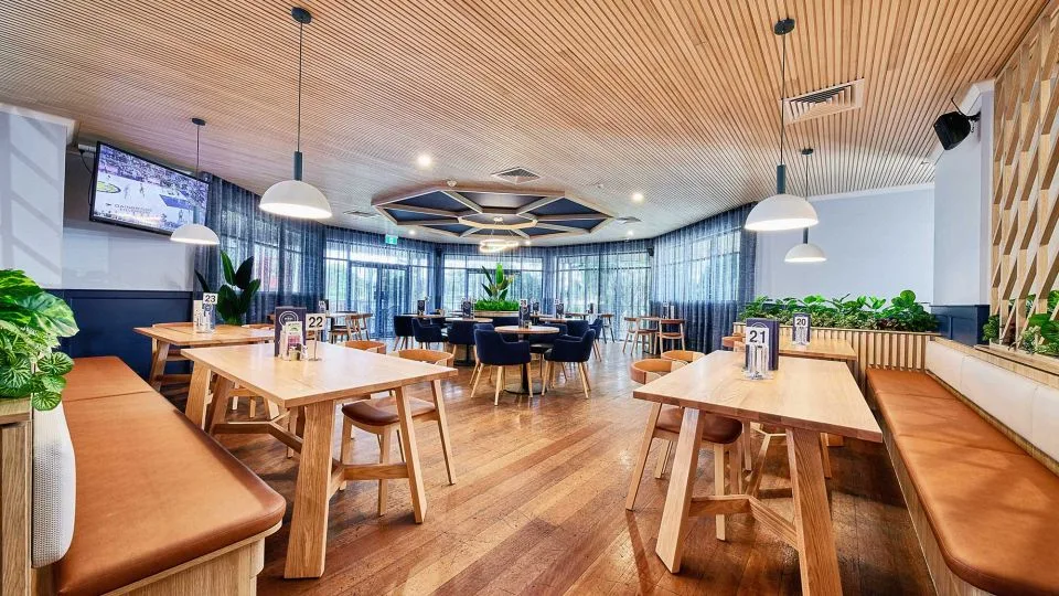 Espacio representativo del hotel: Un comedor con mesas de madera, bancos y sillas.