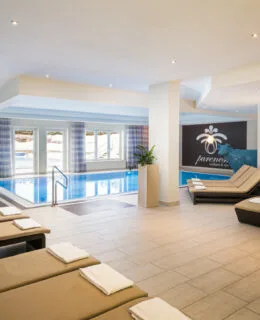 Representative hotel space: An indoor pool area with lounge seating and large windows.