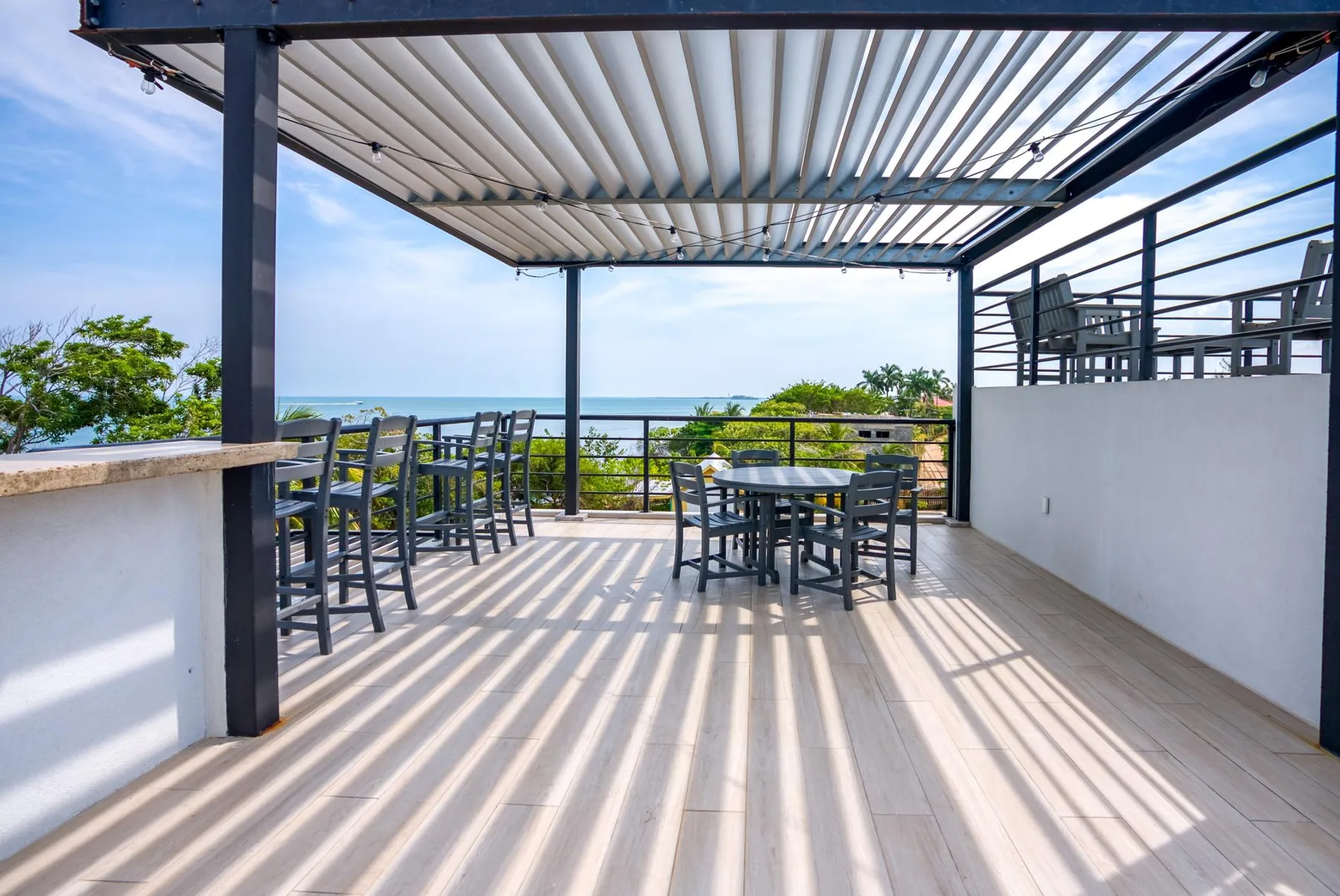 Shared amenity: Outdoor terrace with dining tables and chairs overlooking the sea.
