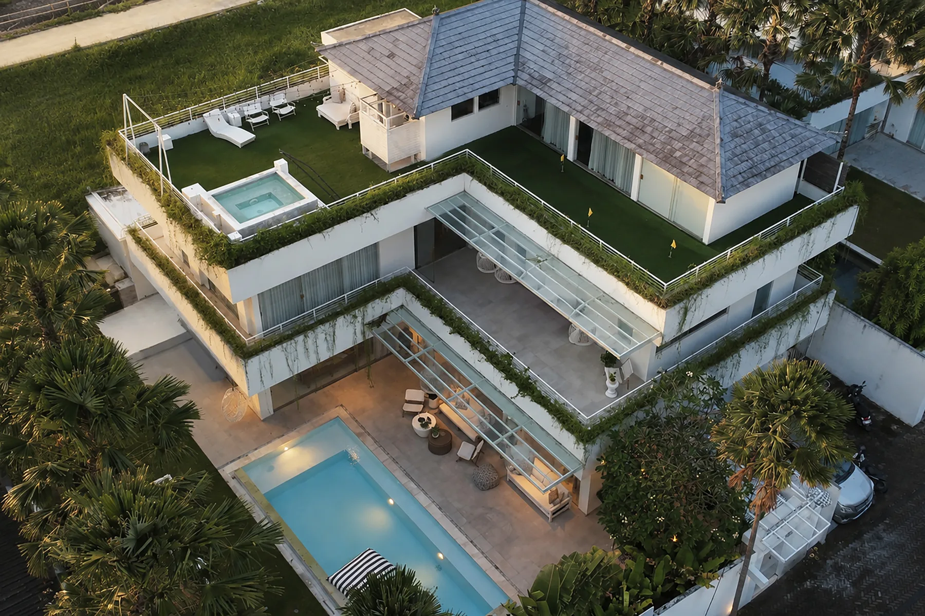 Vista aérea de una casa moderna con terrazas en la azotea y una piscina.