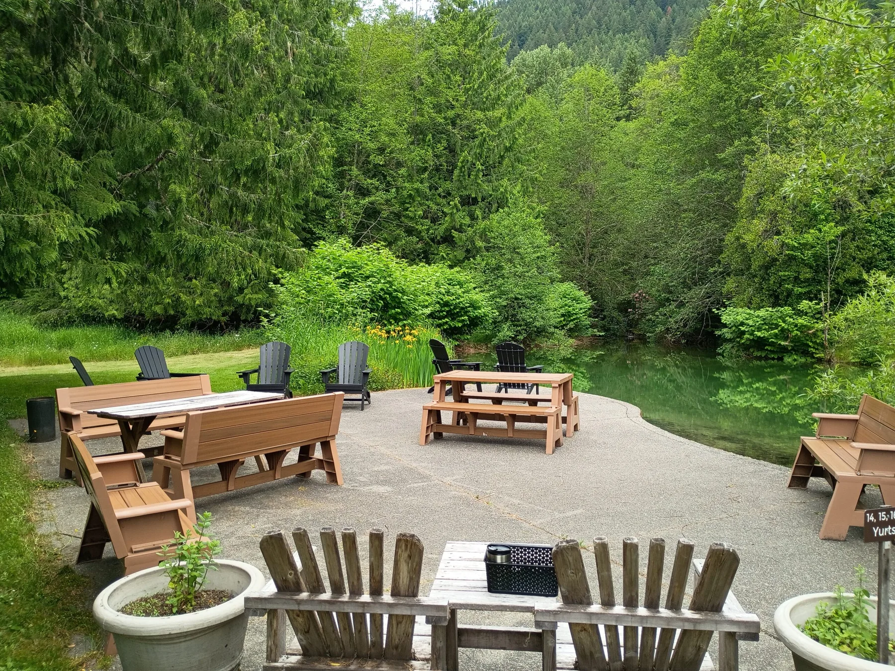 Representative hotel space: An outdoor patio with wooden seating overlooks a tree-lined pond.