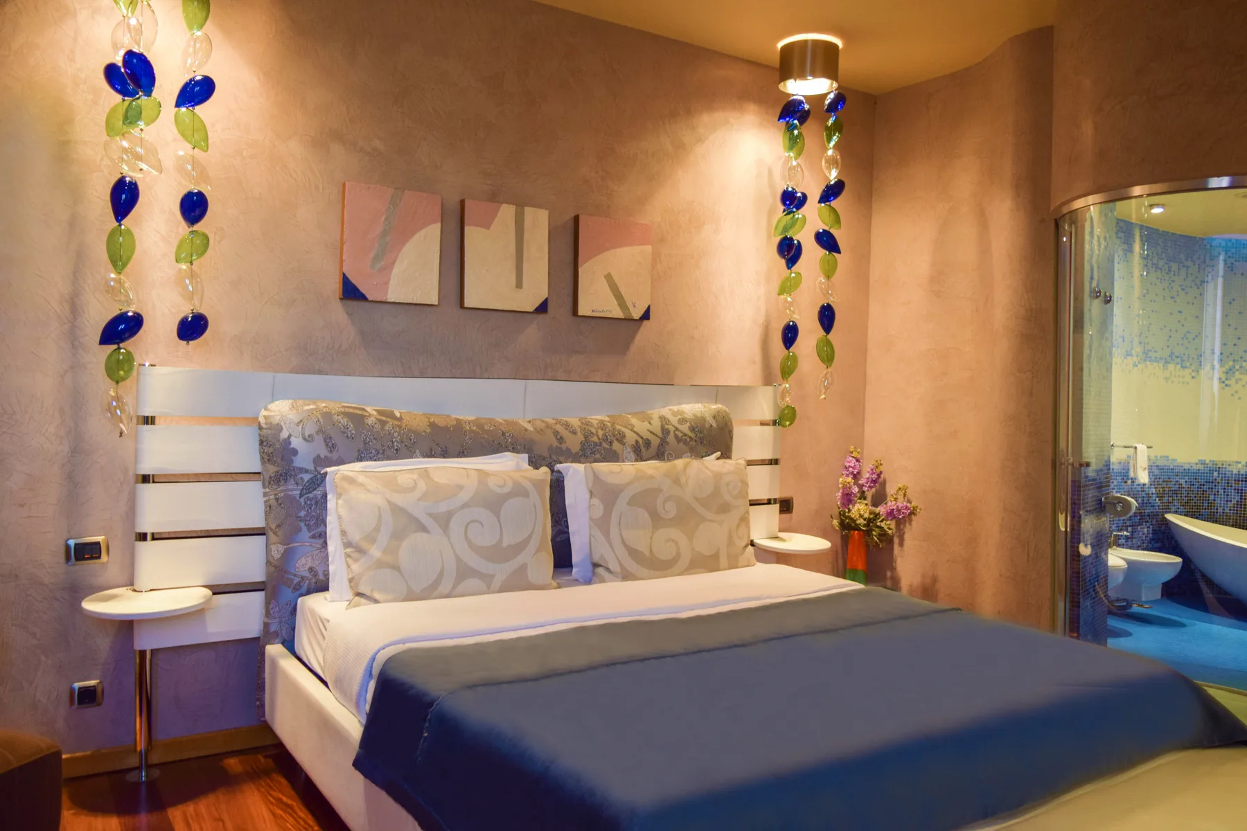 Representative hotel space: A bedroom with a large bed and colorful hanging decorations.