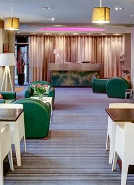 Representative hotel space: Hotel lounge with green seating and a fireplace.