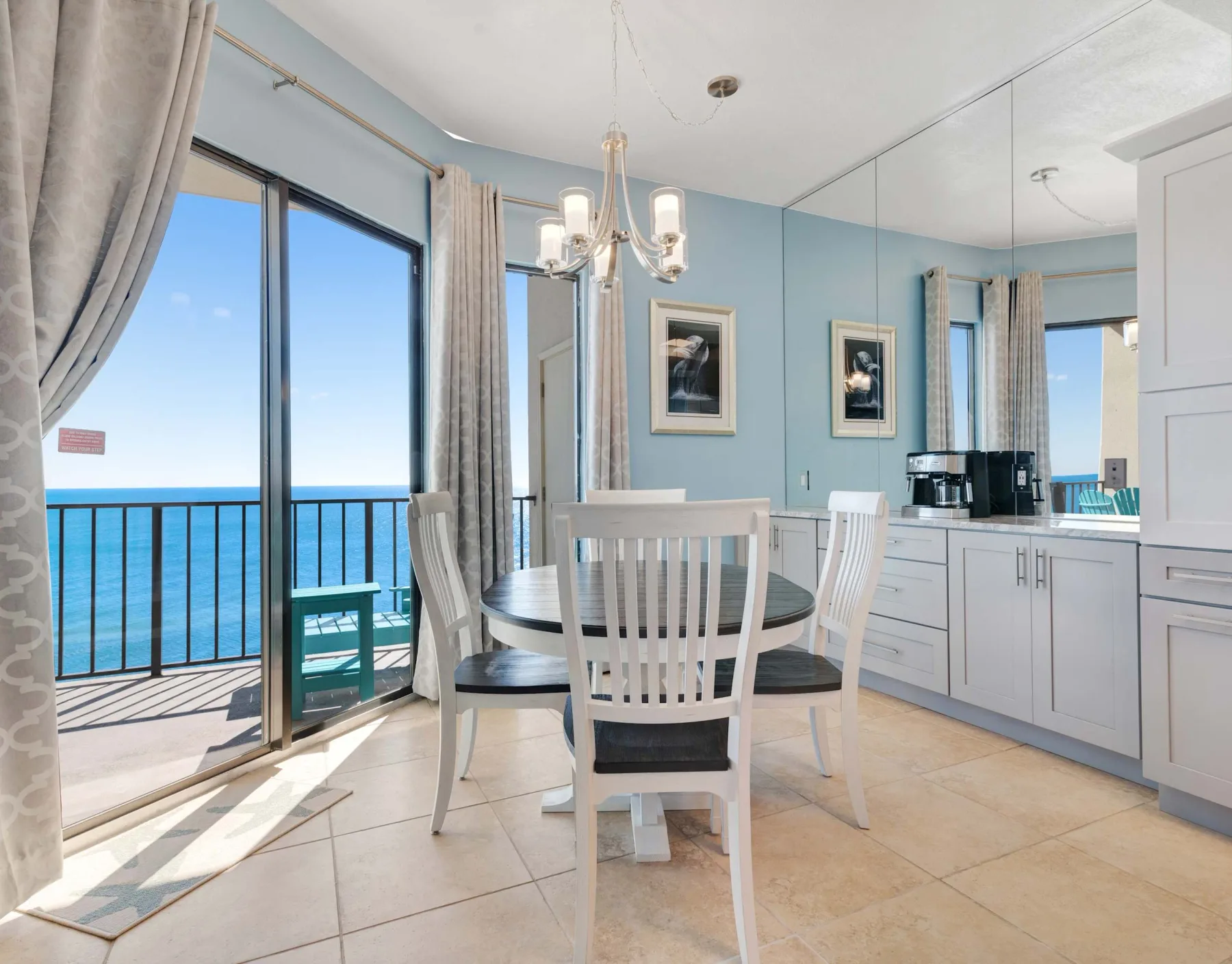 Comedor con una mesa redonda junto a puertas corredizas de vidrio con vistas al mar.