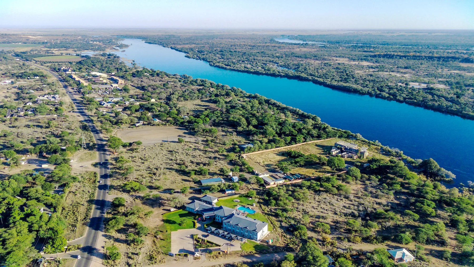 Espacio representativo del hotel: Vista aérea de un asentamiento junto al río, con casas dispersas y vegetación.