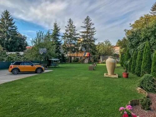 Representative hotel space: A landscaped garden with a lawn, trees, and a large decorative urn.