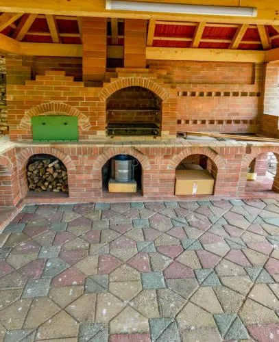 Representative hotel space: A brick outdoor cooking area with arched ovens beneath a wooden roof.