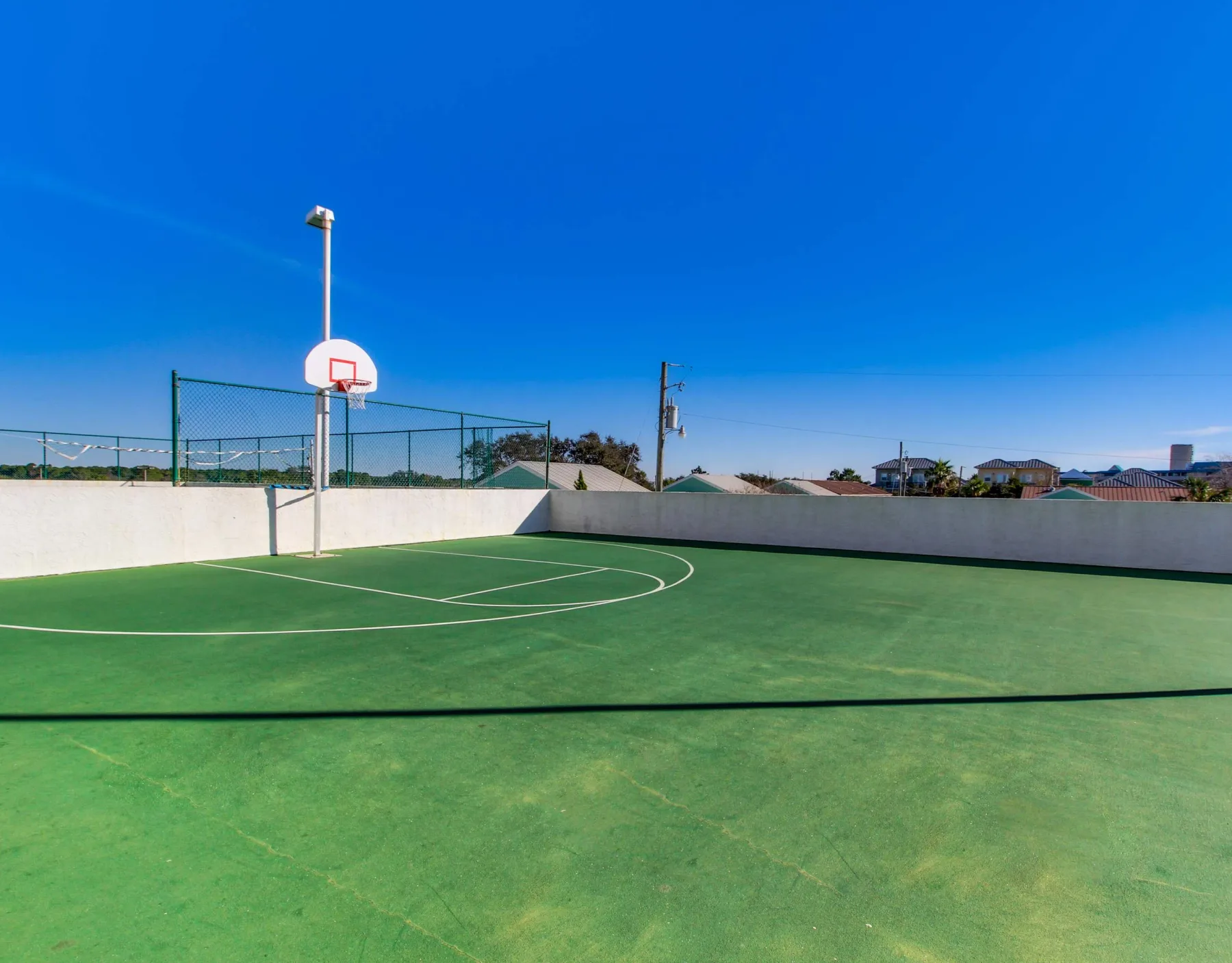 Shared amenity: Outdoor basketball court with a green playing surface and hoop.