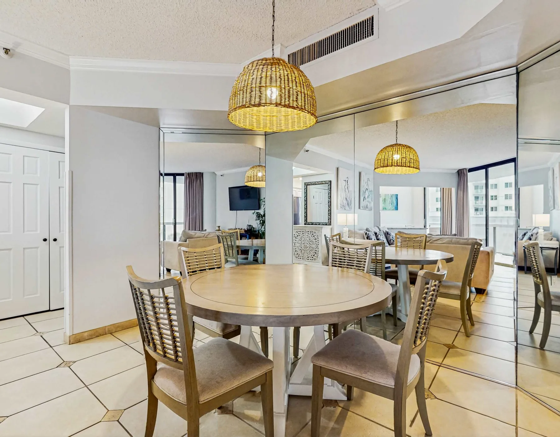 A dining area with round tables and woven pendant lighting.