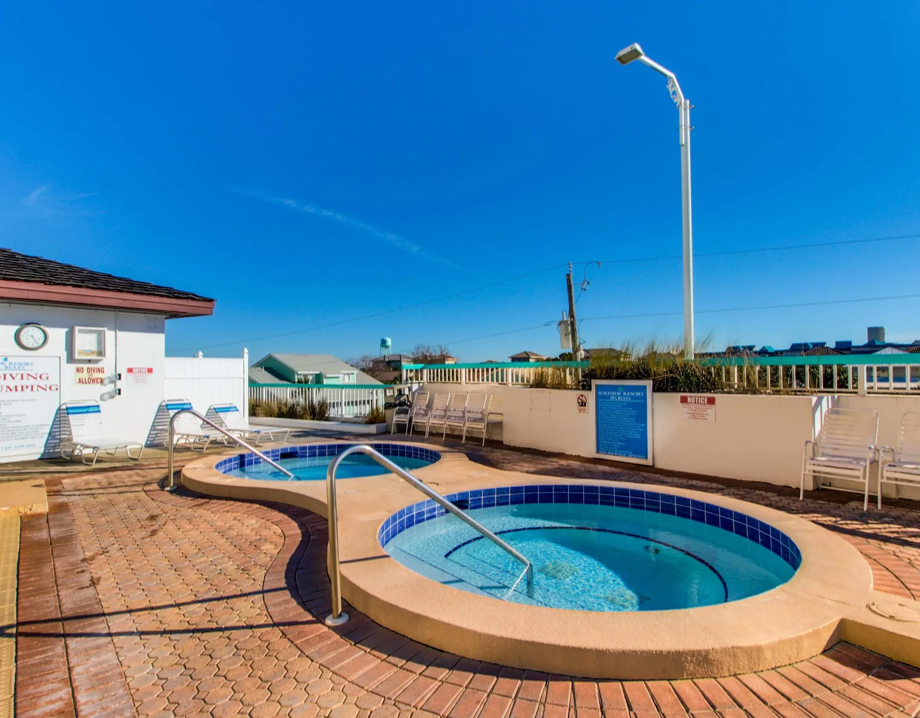Shared amenity: Outdoor pool area with a round, tiled spa beside the swimming pool.