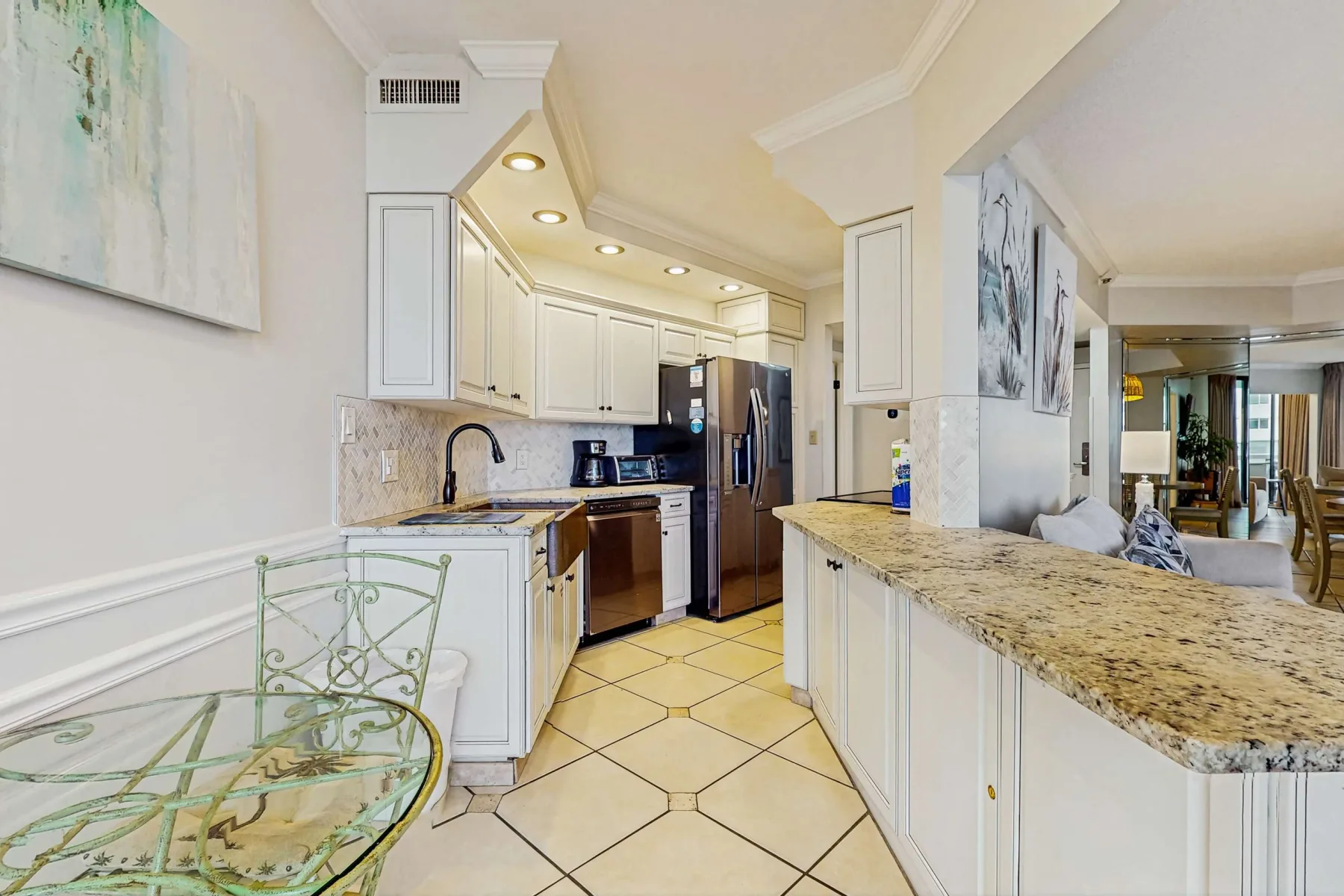 A bright kitchen with white cabinetry and a stone-topped island.