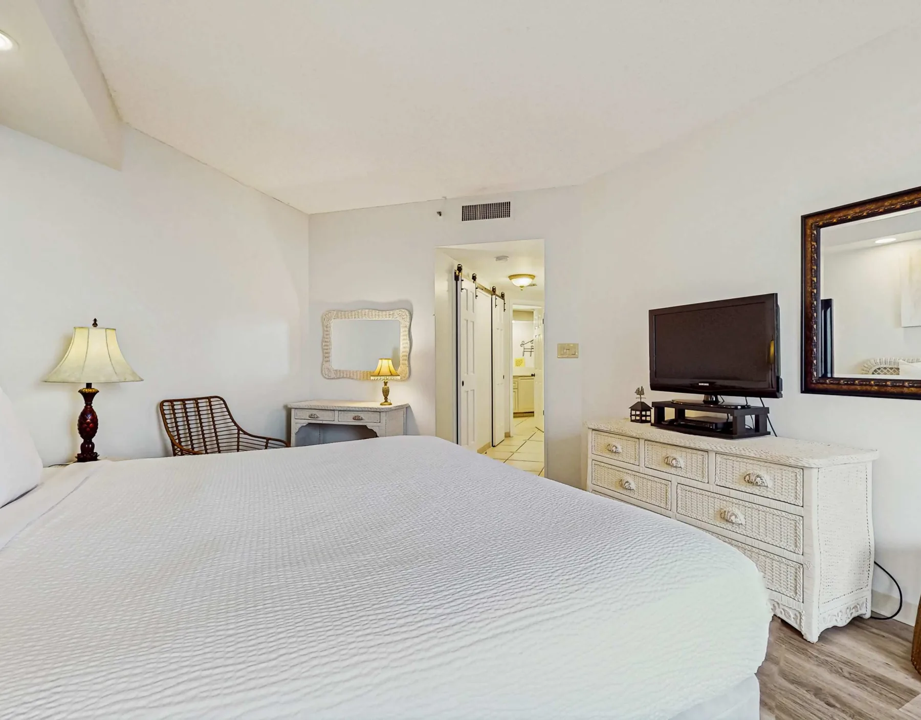 A bedroom with a bed, television, and doorway to a bathroom.