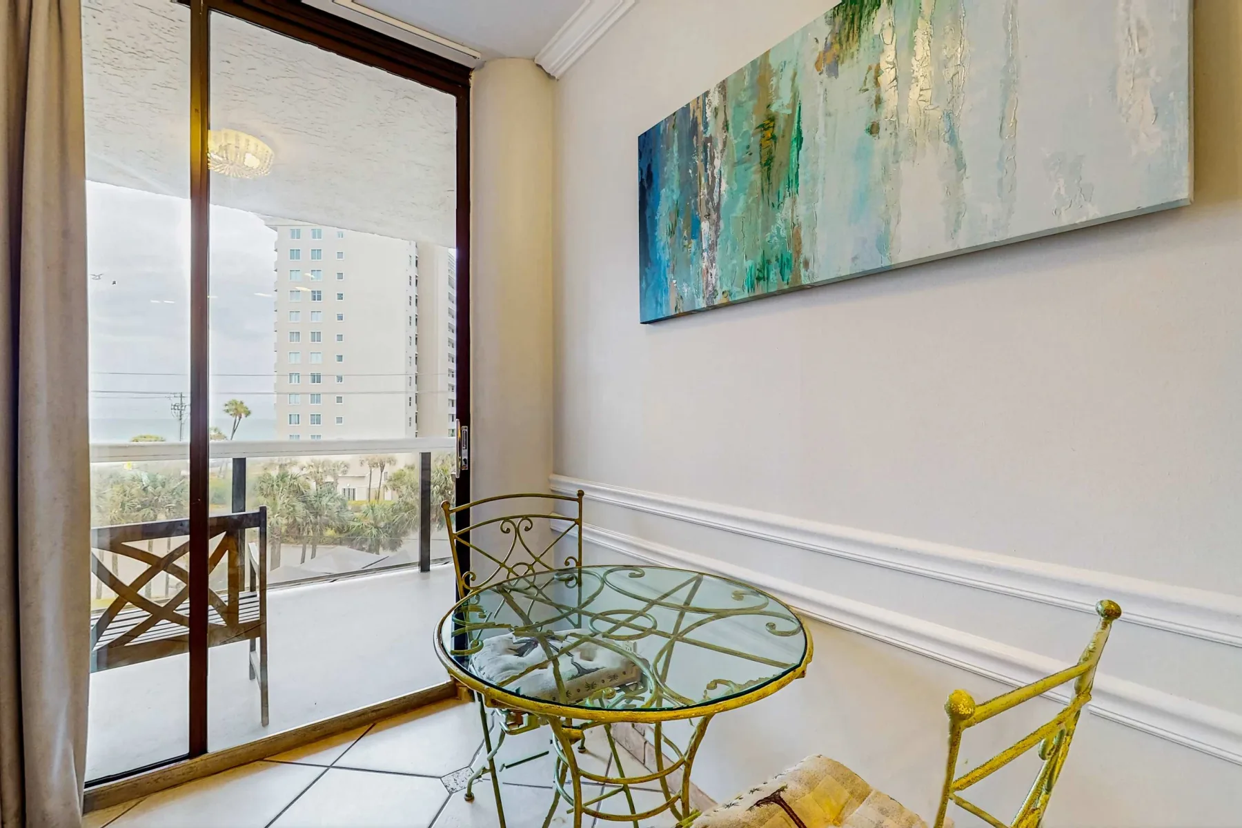 A bright dining nook with a glass table beside a large window.