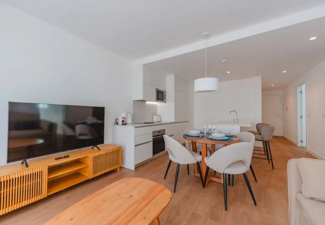 Una sala de estar y comedor diáfana con un televisor y una mesa de comedor.