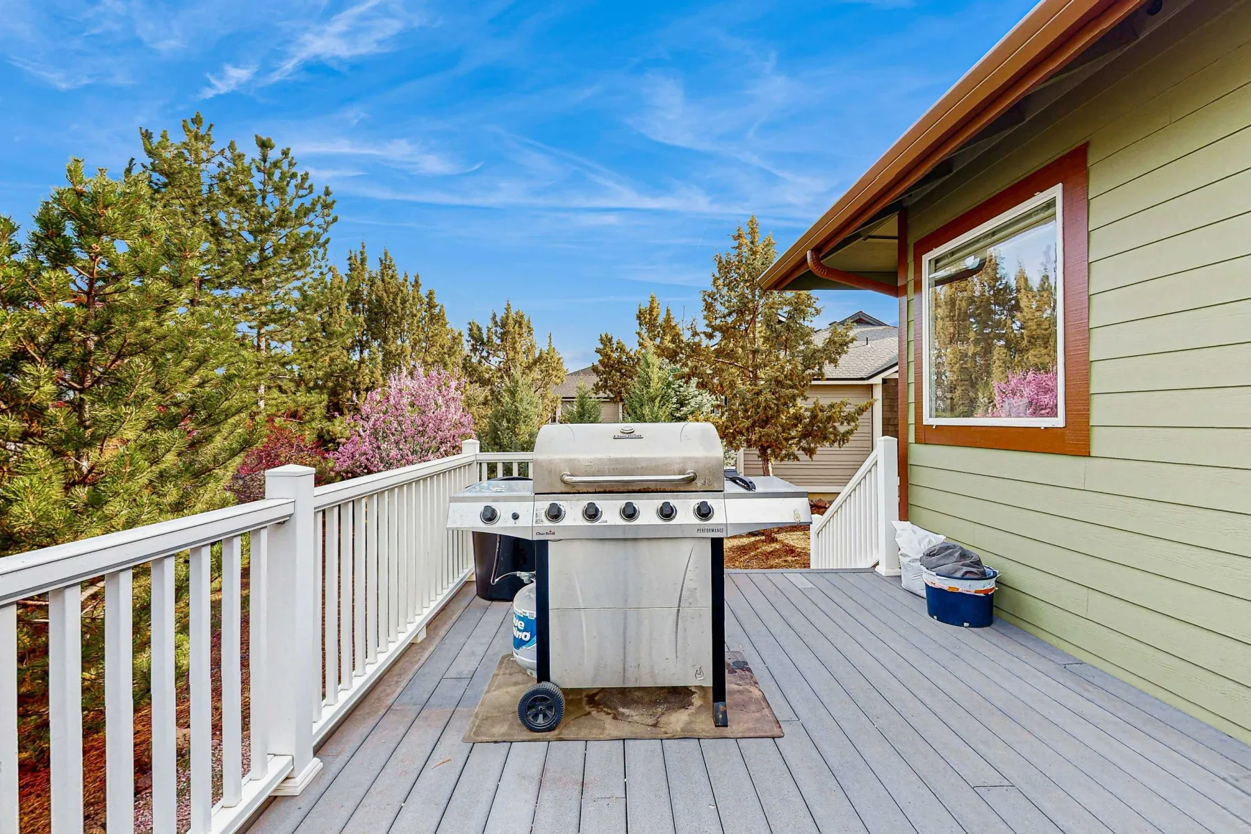 Una terraza exterior con una parrilla junto a una casa.