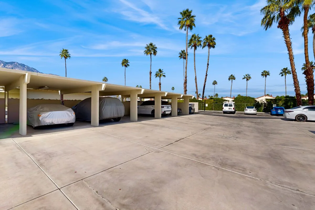 Shared amenity: A parking area with covered spaces and several parked cars.