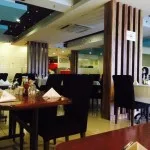 Espacio representativo del hotel: Un comedor con mesas, sillas y columnas decorativas.
