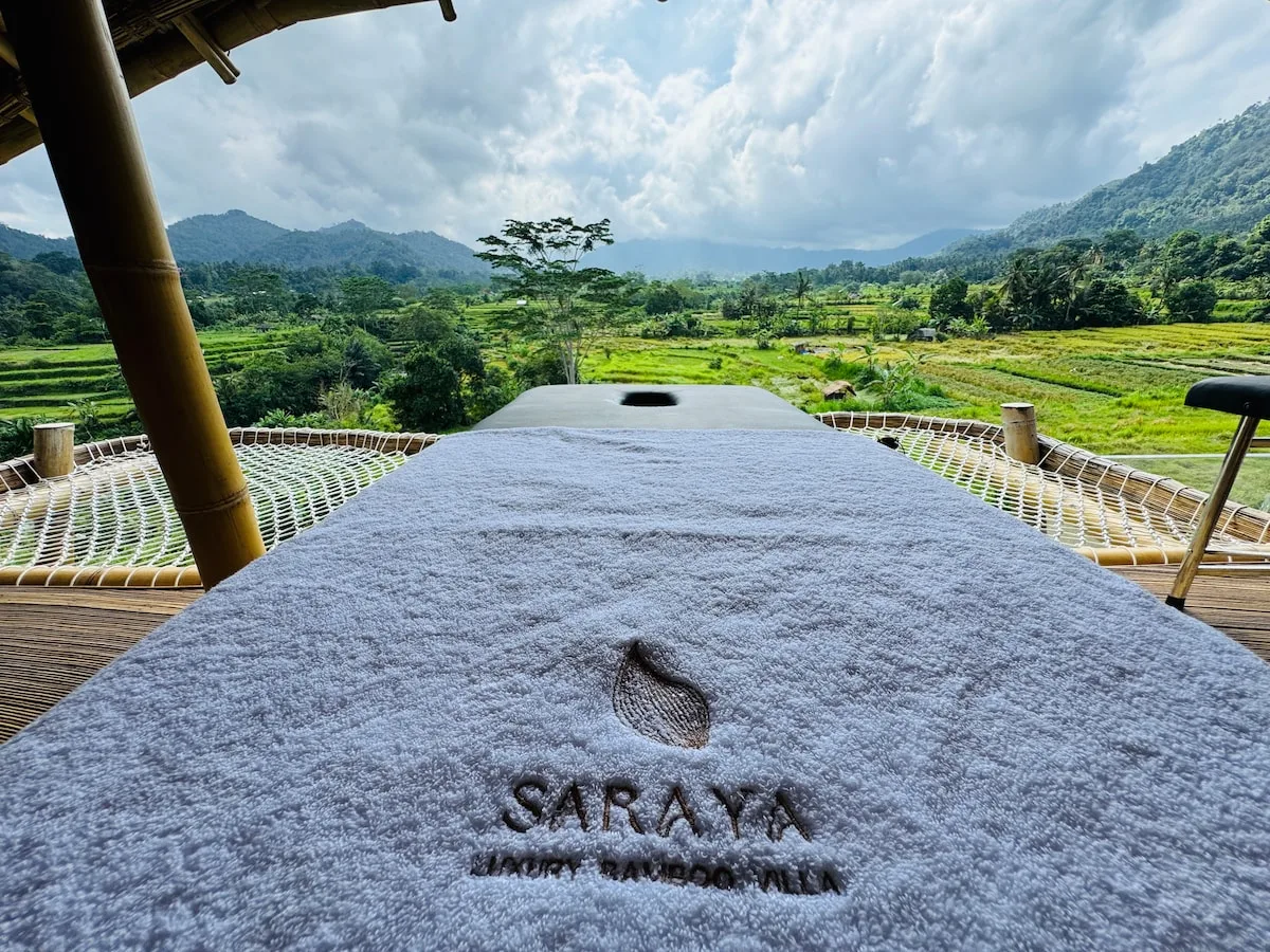 An outdoor relaxation area overlooks green fields and forested hills.
