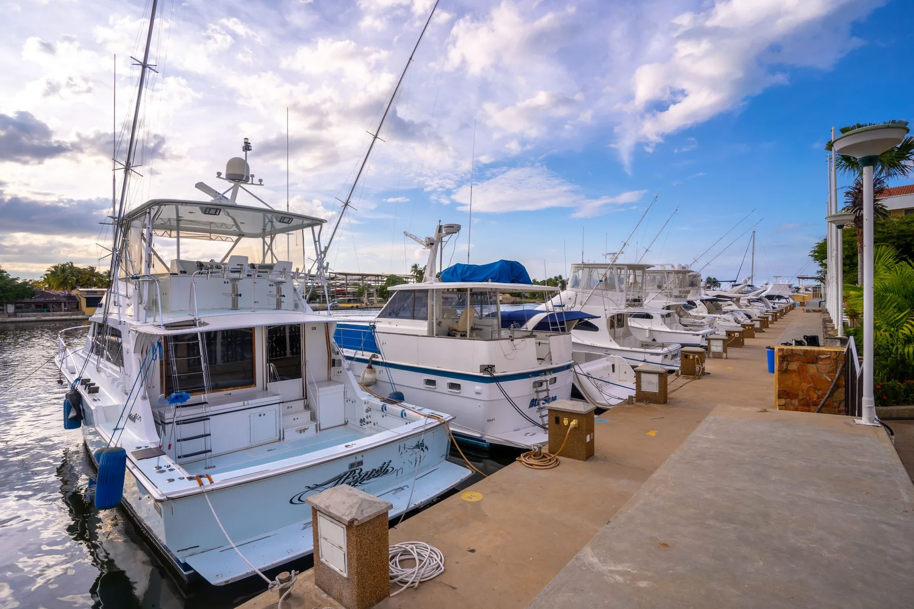 Espacio representativo del hotel: Un muelle de marina con barcos amarrados bajo un cielo parcialmente nublado.