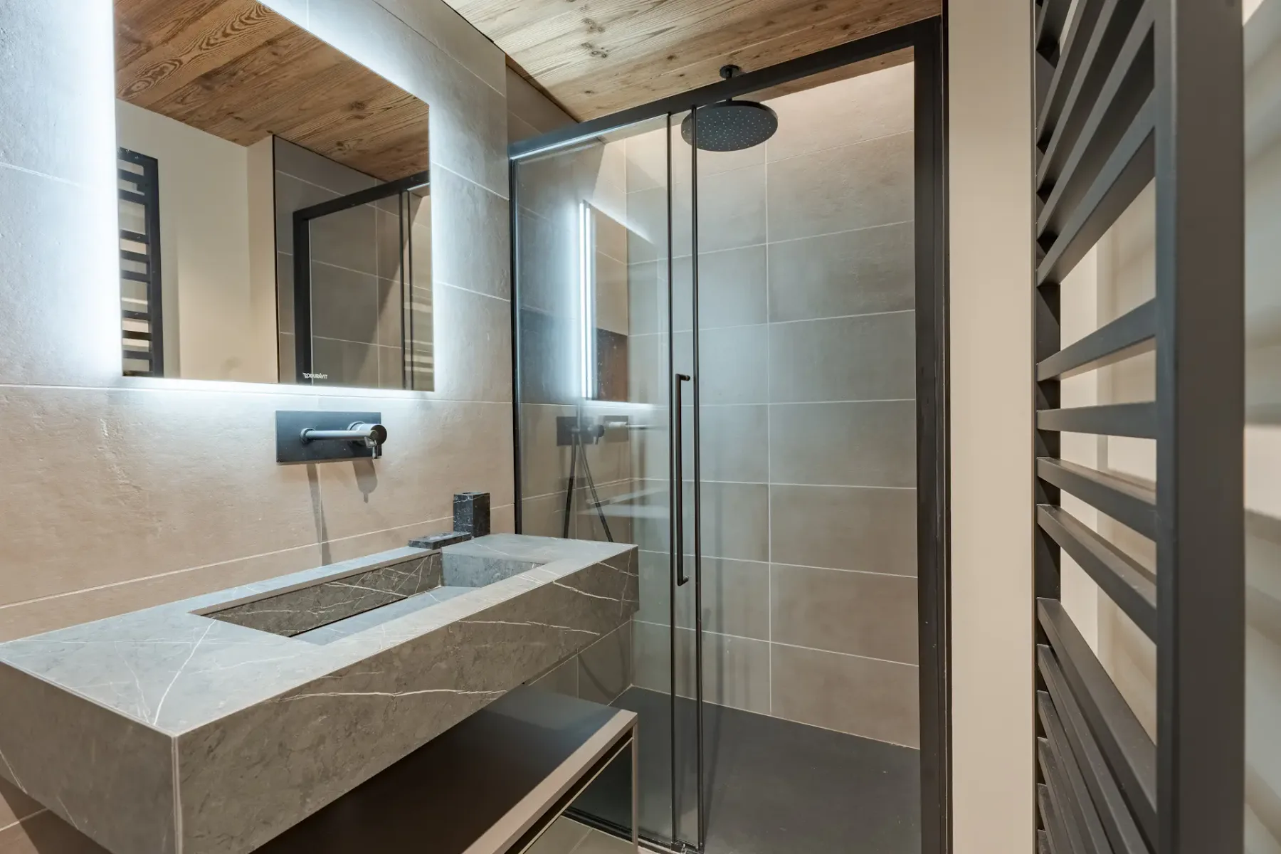 Un baño moderno con lavabo de piedra y ducha de vidrio.