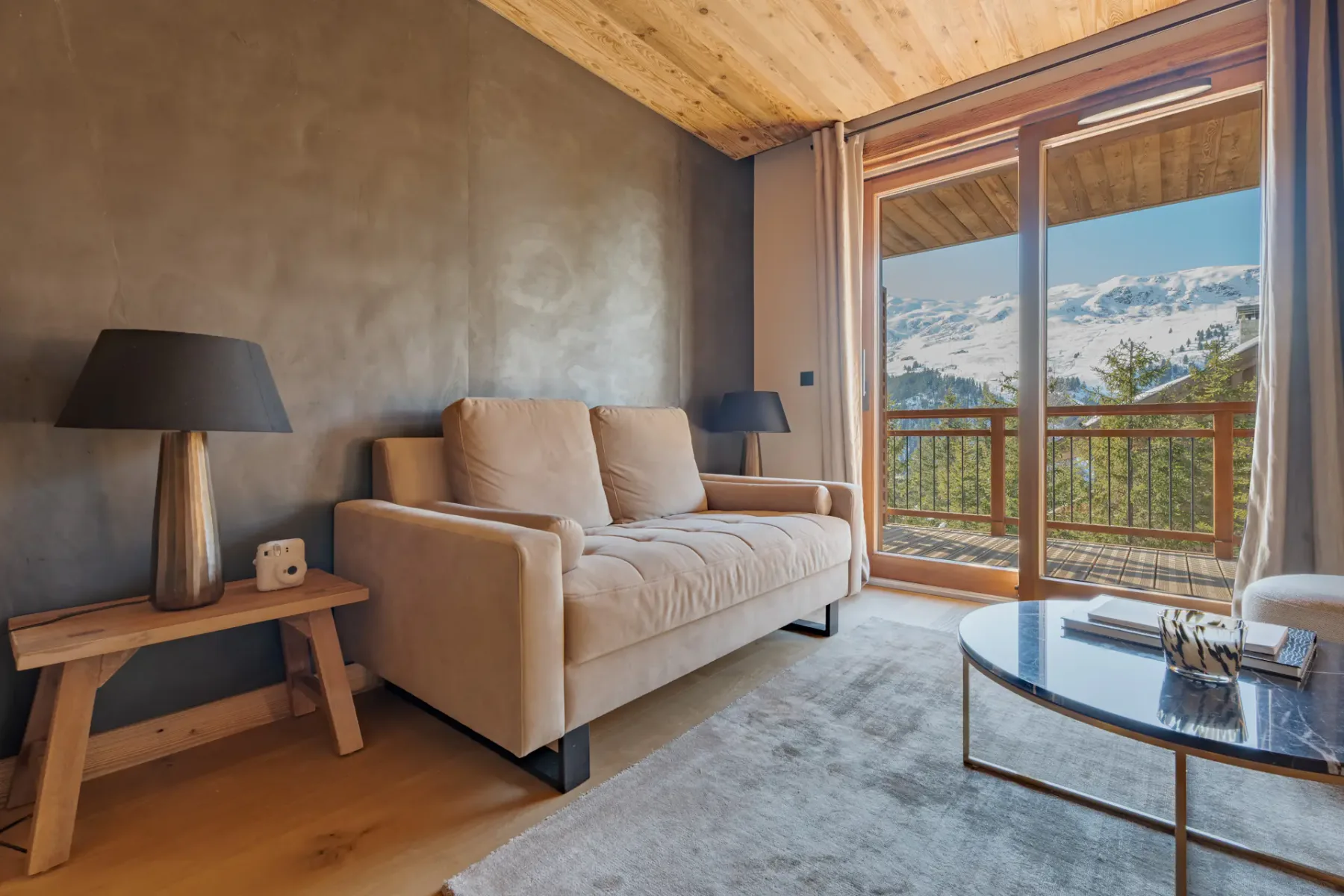 Una sala de estar con asientos junto a una puerta de vidrio y vistas a las montañas.