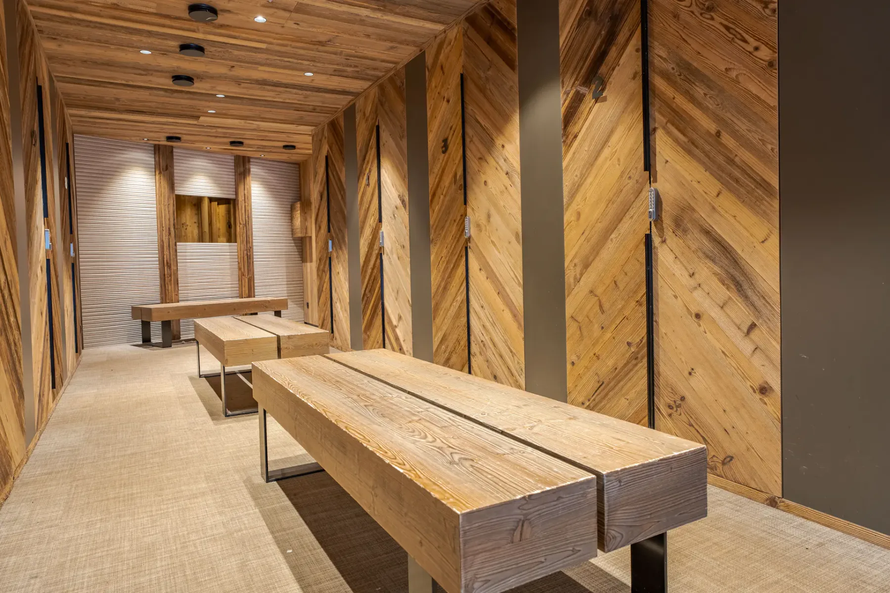 Zona común: Una sala revestida de madera con mesas largas y bancos.
