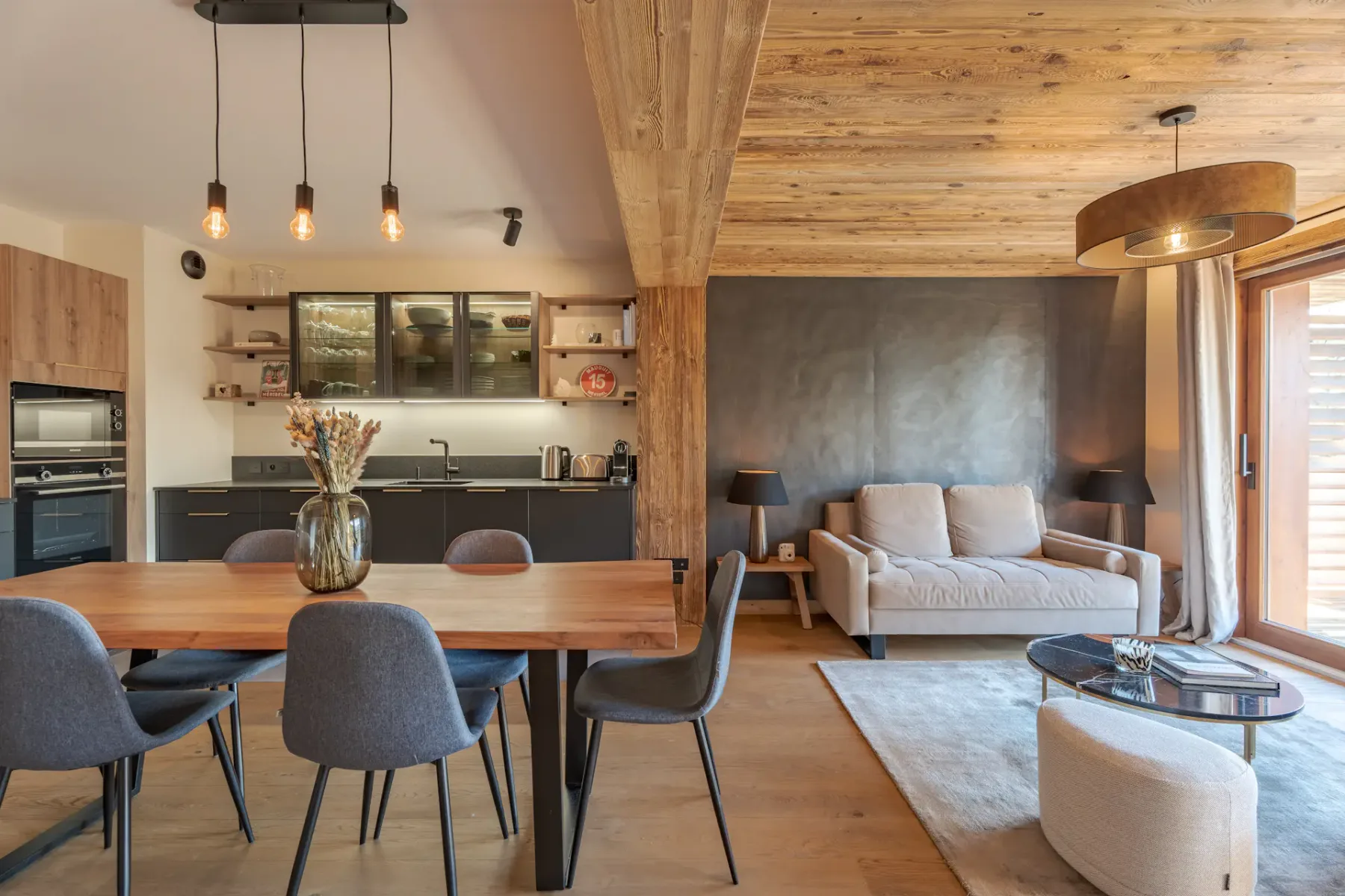Una sala-comedor de concepto abierto con cocina y ventanas amplias.
