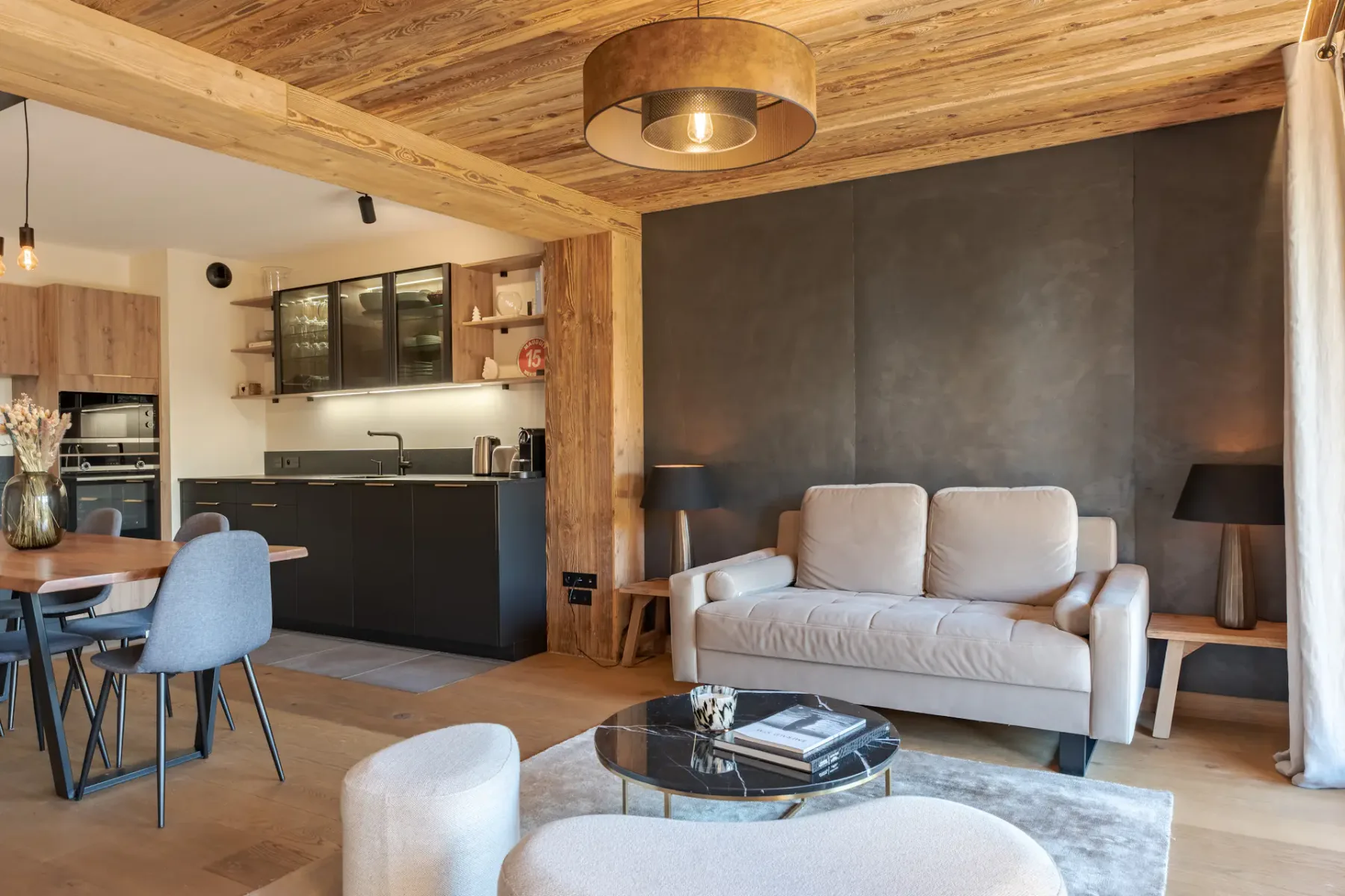 Una sala-comedor de planta abierta con un sofá claro junto a la cocina.