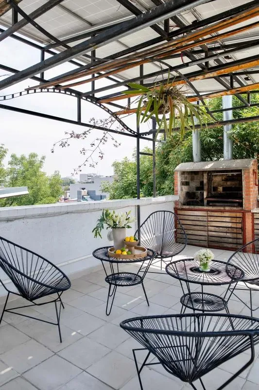 Shared amenity: A covered patio with wire seating and a brick barbecue.