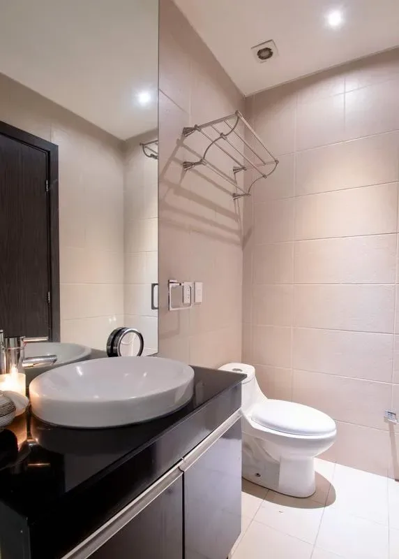 A tiled bathroom with a sink vanity and toilet.