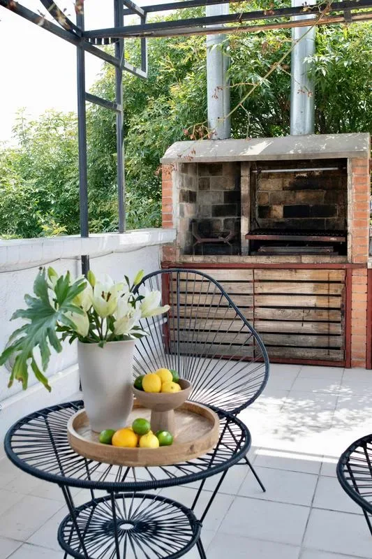 Shared amenity: A tiled patio with a brick barbecue and a small table with fruit.