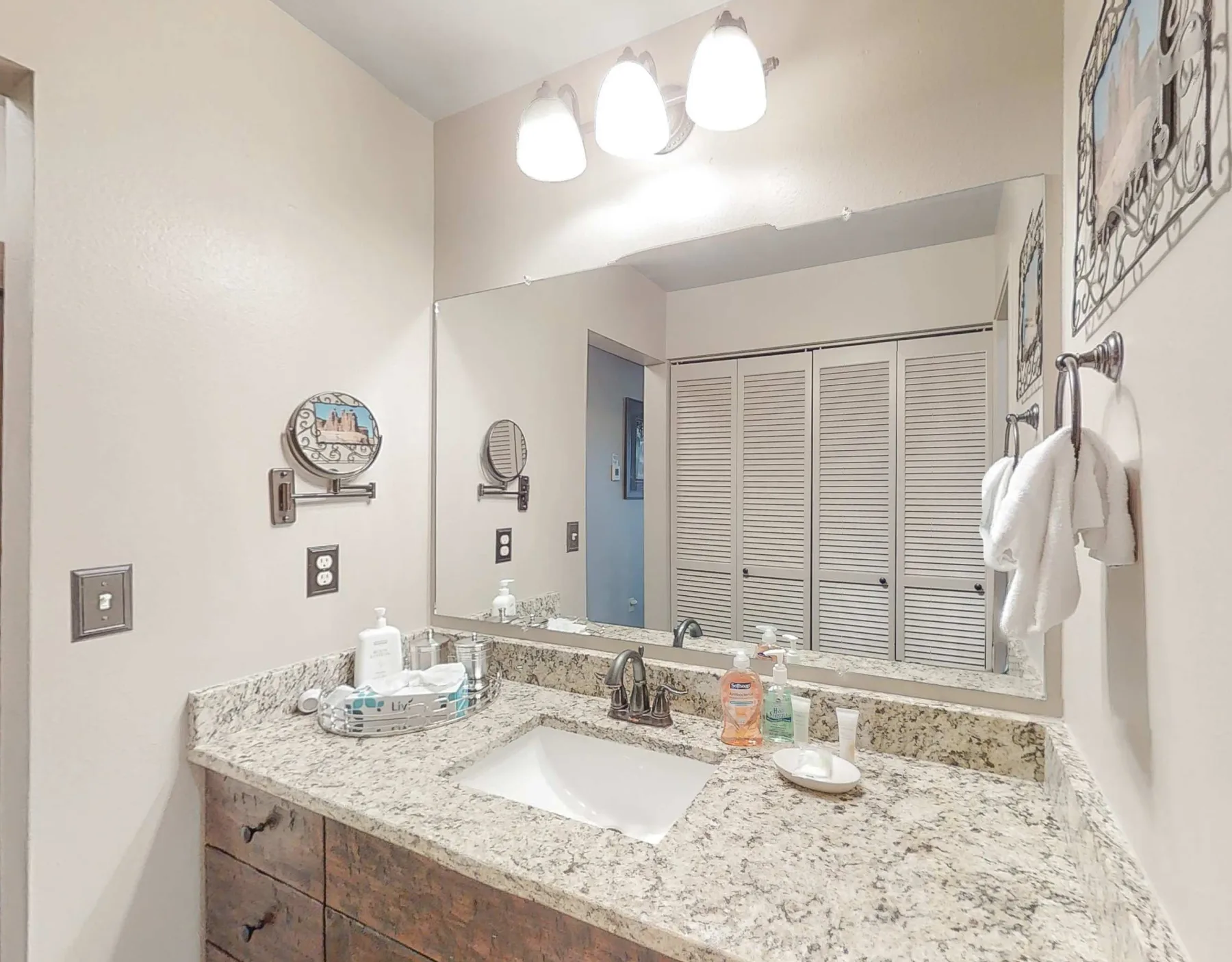 Un tocador de baño con lavabo, un espejo grande y luces en la parte superior.