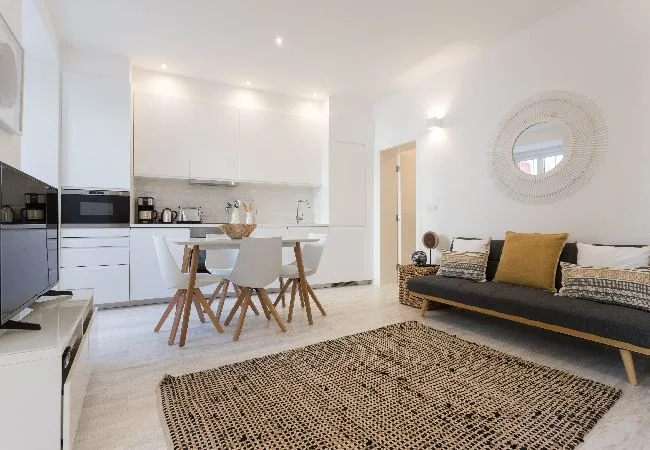 A bright living room with a dining table, kitchen, and seating area.