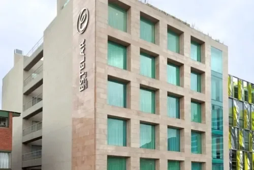 Espacio representativo del hotel: Exterior de hotel con una cuadrícula de ventanas turquesas.