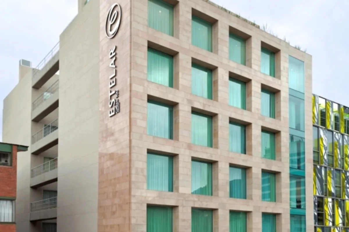 Espacio representativo del hotel: Exterior de un hotel de varios pisos con una cuadrícula de ventanas turquesas.