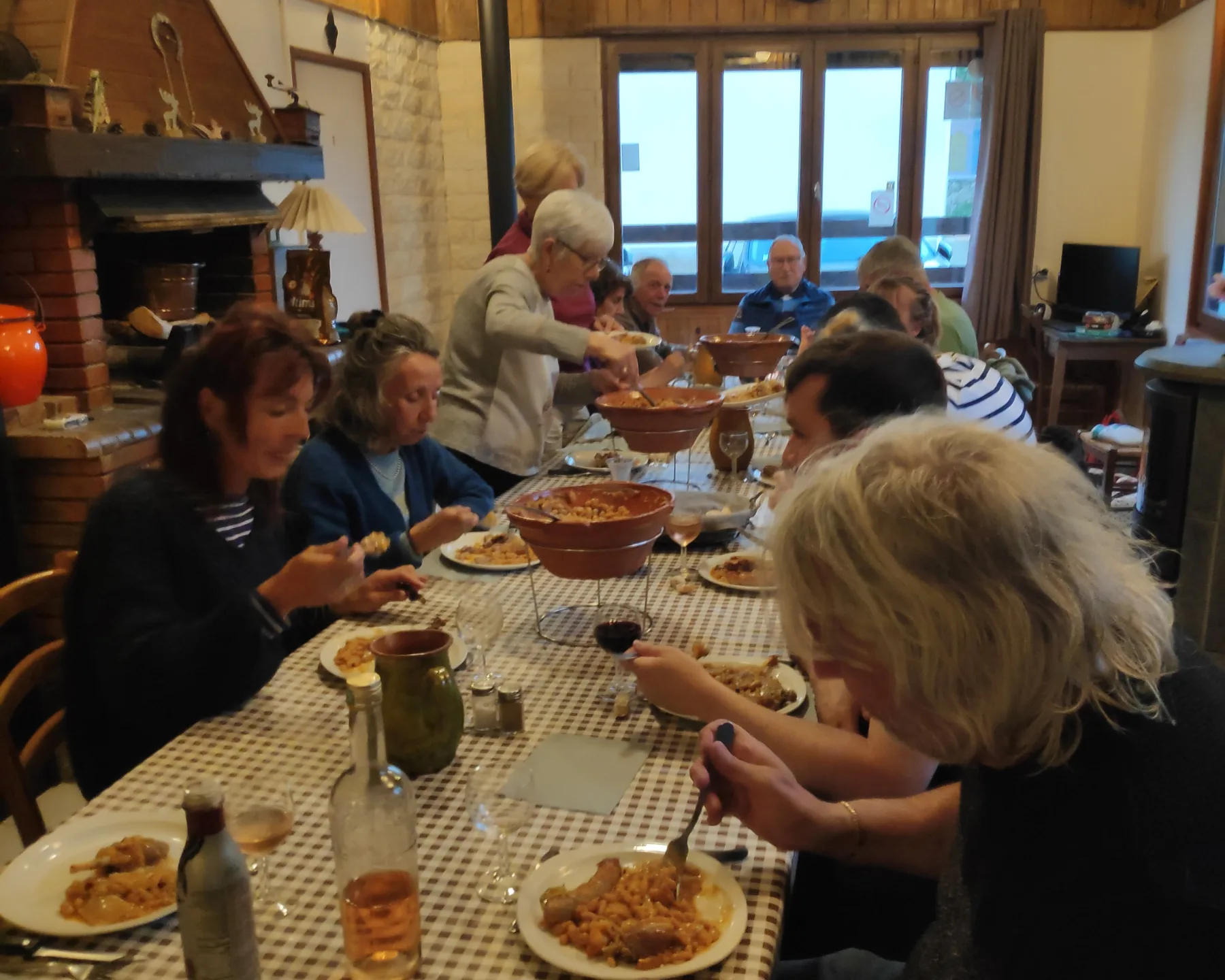 Representative hotel space: People gather around a dining table for a meal in a wood-paneled room.